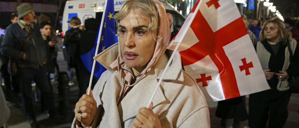 Eine Frau hält eine EU- und eine georgische Nationalflagge während eines Protestes der Opposition gegen die Ergebnisse der Parlamentswahlen.