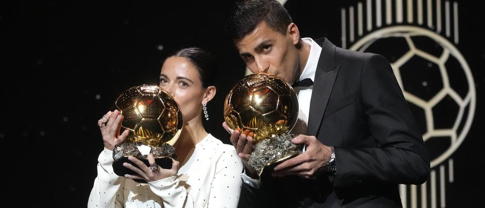 Barcelonas spanische Spielerin Aitana Bonmati, links, und Manchester Citys spanischer Spieler Rodri küssen ihre Ballon d’Or-Trophäen 2024 während der Verleihung des 68. Ballon d’Or (Goldener Ball) im Theatre du Chatelet in Paris. 