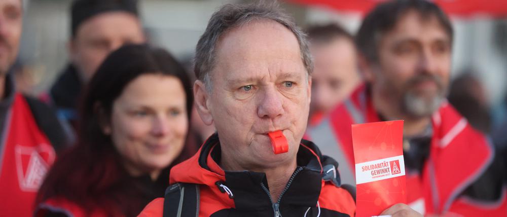 Arbeiter stehen bei einem Warnstreik der IG Metall in Gera am Eingang des Kaeser Werkes.
