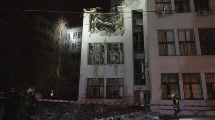 Ukraine, Charkiw: Feuerwehrleute inspizieren das beschädigte Bürogebäude, nachdem es von russischen Lenkbomben im Zentrum getroffen wurde.