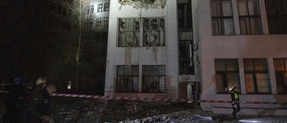 Ukraine, Charkiw: Feuerwehrleute inspizieren das beschädigte Bürogebäude, nachdem es von russischen Lenkbomben im Zentrum getroffen wurde.