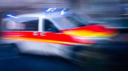 Ein Rettungsfahrzeug ist mit Blaulicht auf einer Straße unterwegs.