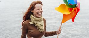 Woman holding pinwheel toy and laughing by lake model released, Symbolfoto, KNSF09749