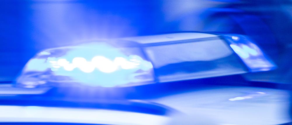 Ein Streifenwagen der Polizei ist mit Blaulicht im Einsatz.
