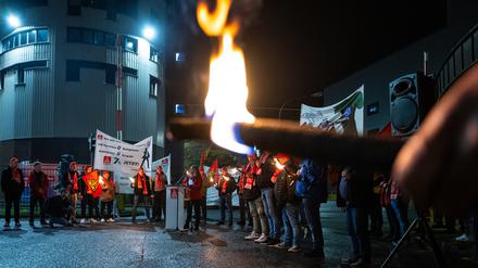Mitarbeiter von Volkswagen stehen mit Fackeln vor dem VW-Werk in Osnabrück.