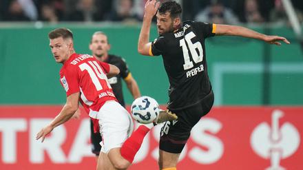 Der Karlsruher SC um Luca Pfeiffer (r) setzte sich im DFB-Pokal gegen die Kickers Offenbach um Kristjan Arh Cesen durch.
