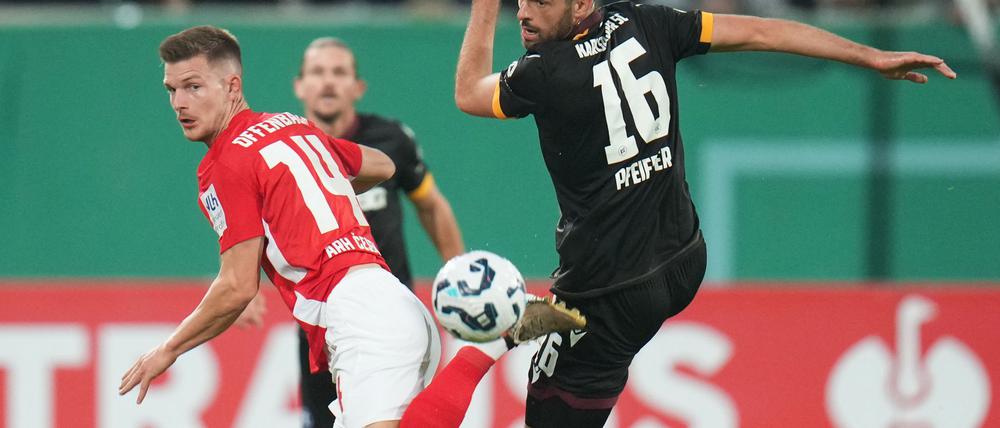Der Karlsruher SC um Luca Pfeiffer (r) setzte sich im DFB-Pokal gegen die Kickers Offenbach um Kristjan Arh Cesen durch.