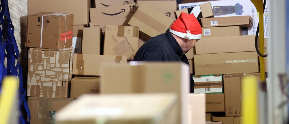 In einer Zustellbasis von DHL wird ein LKW mit Paketen entladen.
