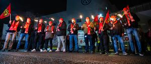 Mitarbeiter von Volkswagen stehen mit Fackeln vor dem Werk in Osnabrück. 