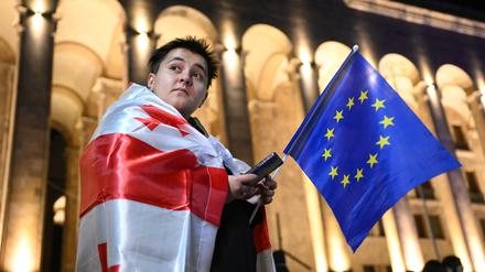 Ein Anhänger der Opposition mit der Nationalflagge Georgiens und der EU-Flagge in Tiflis.