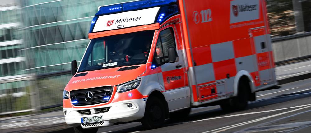 Ein Rettungswagen des Malteser Hilfsdienstes ist mit eingeschaltetem Blaulicht auf dem Weg zum Universitätsklinikum.