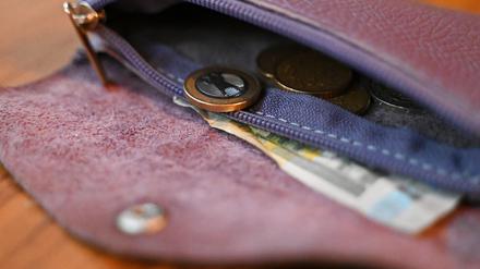 Münzen und ein Fünf-Euroschein liegen in einer Geldbörse. Das Statistische Bundesamt hat die Inflationsrate für Oktober 2024 bekannt gegeben.