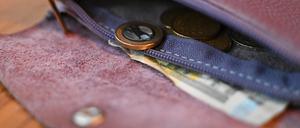 Münzen und ein Fünf-Euroschein liegen in einer Geldbörse. Das Statistische Bundesamt hat die Inflationsrate für Oktober 2024 bekannt gegeben.
