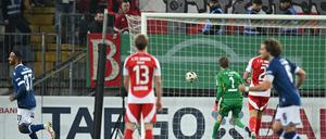 Berlins Torwart Frederik Rönnow (M) kann den Schuss zum 1:0 durch Bielefelds Marius Wörl nicht halten.