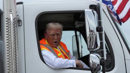 Der republikanische Präsidentschaftskandidat und ehemalige US-Präsident Donald Trump spricht zu Reportern, während er in einem Müllwagen sitzt.