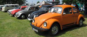 Mehrere VW Käfer in verschiedenen Farben und in unterschiedlichen Ausführungen. Im Vordergrund das Sondermodell 1200 Jeans Käfer (Baujahr 1975, Farbe: Nepalorange). 