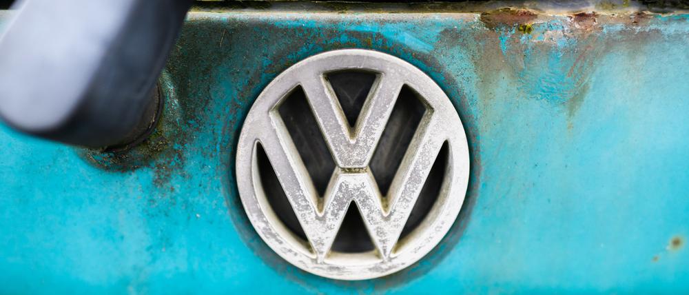 Ein VW-Logo ist auf einem verwitterten alten Volkswagen bei einem Autoverwerter zu sehen.