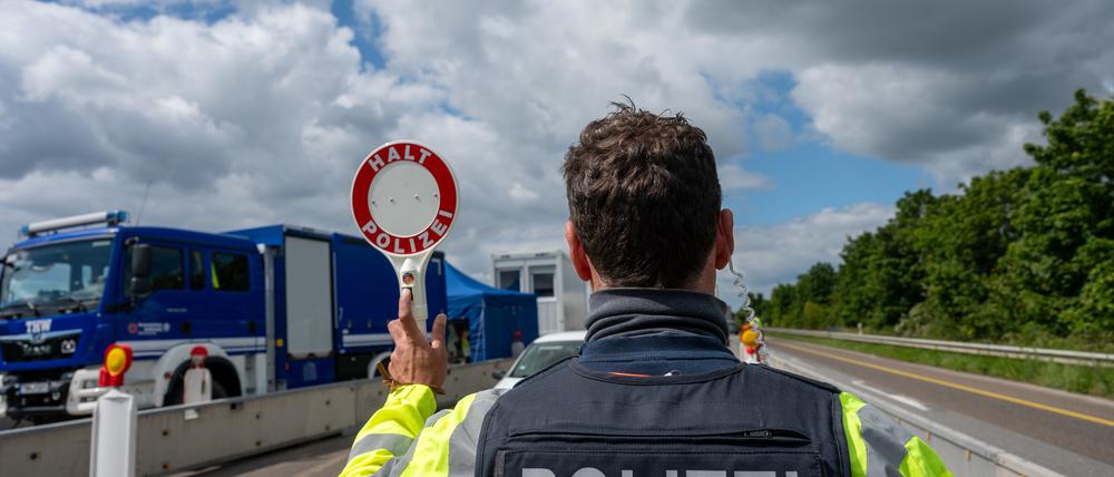 Rheinland-Pfalz, Trier: Ein Bundespolizist hält auf der A64 mit einer Kelle ein Fahrzeug an.