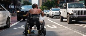 Ein Rollstuhlfahrer auf einer belebten Straße in Manhattan.