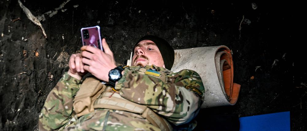 Ein Soldat der ukrainischen Streitkräfte schaut in der Region Saporischschja auf sein Handy (Archivbild aus dem November 2022).