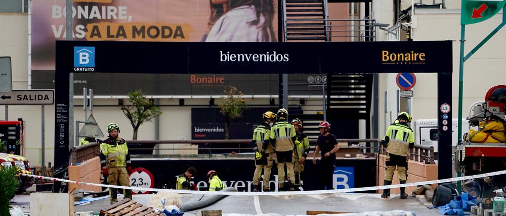 Feuerwehrleute sind am Eingang zum Parkplatz des Einkaufszentrums Bonaire in Aldaia bei Valencia in Spanien im Einsatz. 