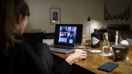 28.03.2020, Schweiz, Bern: Eine Frau sitzt während der Corona-Pandemie an einem Tisch in ihrer Wohnung vor einem Laptop, während sie mit weiteren fünf Personen an einer Videokonferenz mit der Videokonferenzanwendung «Zoom» teilnimmt. Foto: Anthony Anex/KEYSTONE/dpa +++ dpa-Bildfunk +++