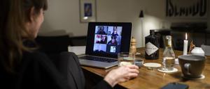 28.03.2020, Schweiz, Bern: Eine Frau sitzt während der Corona-Pandemie an einem Tisch in ihrer Wohnung vor einem Laptop, während sie mit weiteren fünf Personen an einer Videokonferenz mit der Videokonferenzanwendung «Zoom» teilnimmt. Foto: Anthony Anex/KEYSTONE/dpa +++ dpa-Bildfunk +++