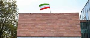 Eine Frau läuft am Iranischen Generalkonsulat in Frankfurt am Main vorbei. Die Nationalflagge des Irans ist auf dem Dach des Gebäudes zu sehen. 