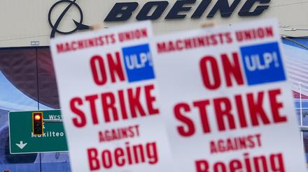 Boeing-Beschäftigte schwenken vor dem Werk Streikpostenschilder. (Archivbild)