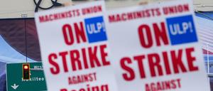 Boeing-Beschäftigte schwenken vor dem Werk Streikpostenschilder. (Archivbild)