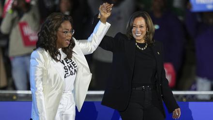 Oprah Winfrey (links) hält einen Arm von Kamala Harris hoch, wie bei einer Siegerverkündung.
