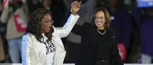 Oprah Winfrey (links) hält einen Arm von Kamala Harris hoch, wie bei einer Siegerverkündung.
