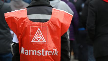 Ein Teilnehmer trägt eine Warnweste mit der Aufschrift «Warnstreik» bei einer Kundgebung der IG Metall.