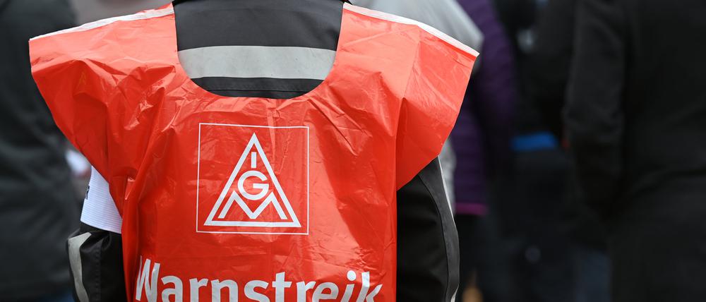 Ein Teilnehmer trägt eine Warnweste mit der Aufschrift «Warnstreik» bei einer Kundgebung der IG Metall.