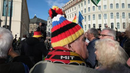 Auf einer Pegida-Demonstration in Dresden. Ein Teilnehmer mit Mütze in den deutschen und russischen Nationalfarben. 