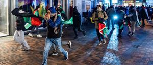 Demonstranten laufen mit palästinensischen Fahnen bei einer propalästinensischen Demonstration während des Spiels Ajax Amsterdam gegen Maccabi Tel-Aviv am Anton de Komplein.