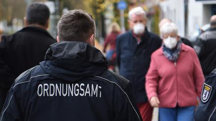 Mitarbeiter vom Ordnungsamt kontrollieren, ob die Passanten auf der Bergmannstraße die Maskenpflicht einhalten.