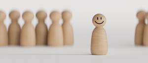 Eine fröhliche Spielfigur steht vor einer Gruppe weiterer Spielfiguren.