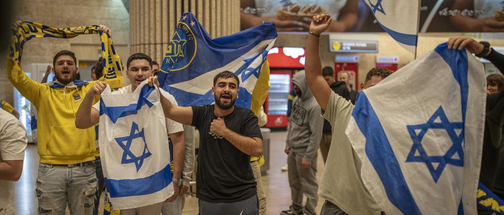 Fans von Maccabi Tel Aviv jubeln, als sie mit einem Flugzeug aus Amsterdam am Flughafen Ben Gurion ankommen.