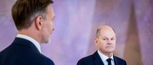Bundeskanzler Olaf Scholz (SPD, r.) schaut im Schloss Bellevue zu Christian Lindner (FDP), ehemaliger Bundesminister der Finanzen.