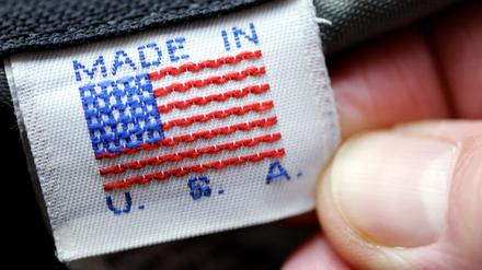 Eine Hand hält ein Etikett „Made in U.S.A.“ an einer Tasche. 