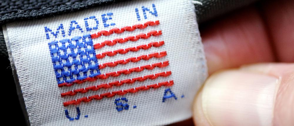 Eine Hand hält ein Etikett „Made in U.S.A.“ an einer Tasche. 