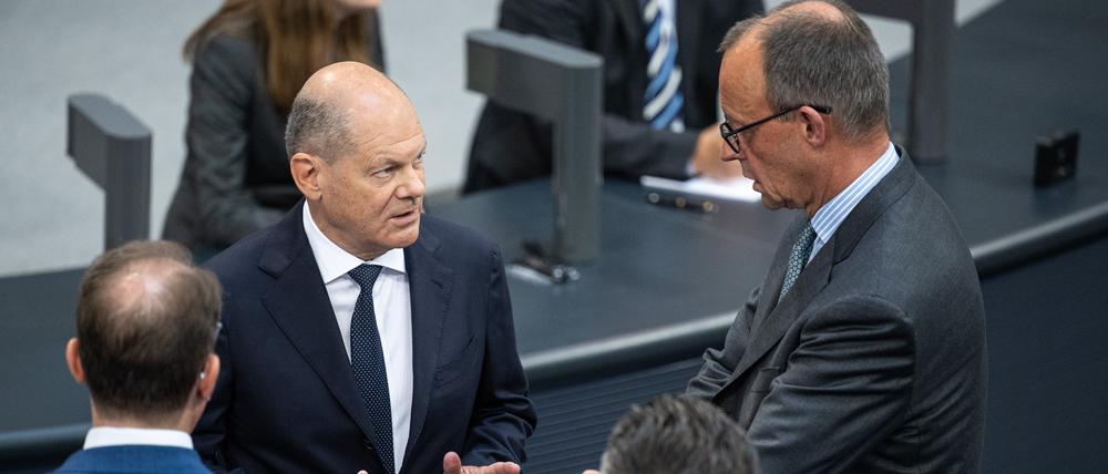 Bundeskanzler Olaf Scholz (SPD, l) und Friedrich Merz, CDU-Bundesvorsitzender und Fraktionsvorsitzender der CDU/CSU-Fraktion im Bundestag, unterhalten sich.