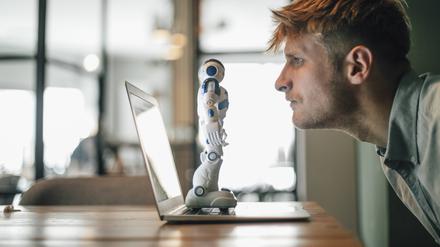 Man looking at toy robot, standing on his laptop model released Symbolfoto property released PUBLICATIONxINxGERxSUIxAUTxHUNxONLY GUSF01281

Therapie2024