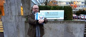 Christian Jung (FDP), Landtagsabgeordneter in Baden-Württemberg, steht mit einer Papierspende vor dem Sitz des Statistischen Bundesamts. 