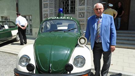 Schauspieler Rolf Schimpf steht 2013 vor dem Polizeipräsidium neben einem alten VW-Käfer-Polizeiauto. Am 14. November wird der Schauspieler 100 Jahre alt.