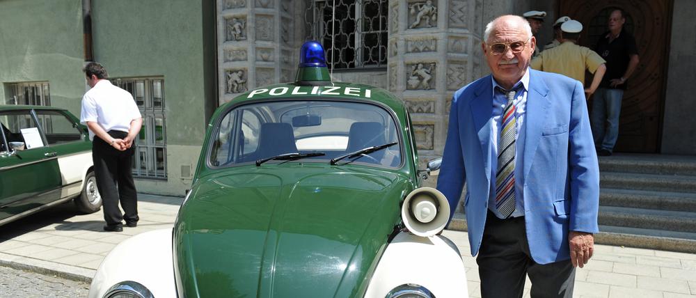Schauspieler Rolf Schimpf steht 2013 vor dem Polizeipräsidium neben einem alten VW-Käfer-Polizeiauto. Am 14. November wird der Schauspieler 100 Jahre alt.