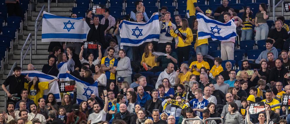 ALBA Berlin - Maccabi Tel Aviv, Mercedes-Benz Arena. Fans von Maccabi Tel Aviv stehen mit Fahnen in der Halle.