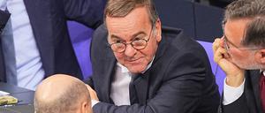 Bundeskanzler Olaf Scholz (SPD, l) spricht auf der Regierungsbank nach seiner Regierungserklärung im Plenum des Bundestags mit Boris Pistorius (SPD, M), Bundesminister der Verteidigung, und Wolfgang Schmidt, Bundesminister für besondere Aufgaben.