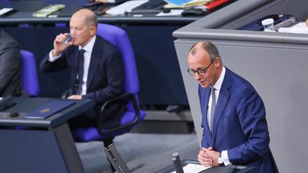 13.11.2024: Deutscher Bundestag: CDU-Chef Friedrich Merz rechts antwortet auf die Regierungserklärung von Bundeskanzler Olaf Scholz SPD, der trinkt aus einem Glas Wasser 
